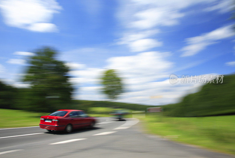 红色汽车在蜿蜒的乡村路上