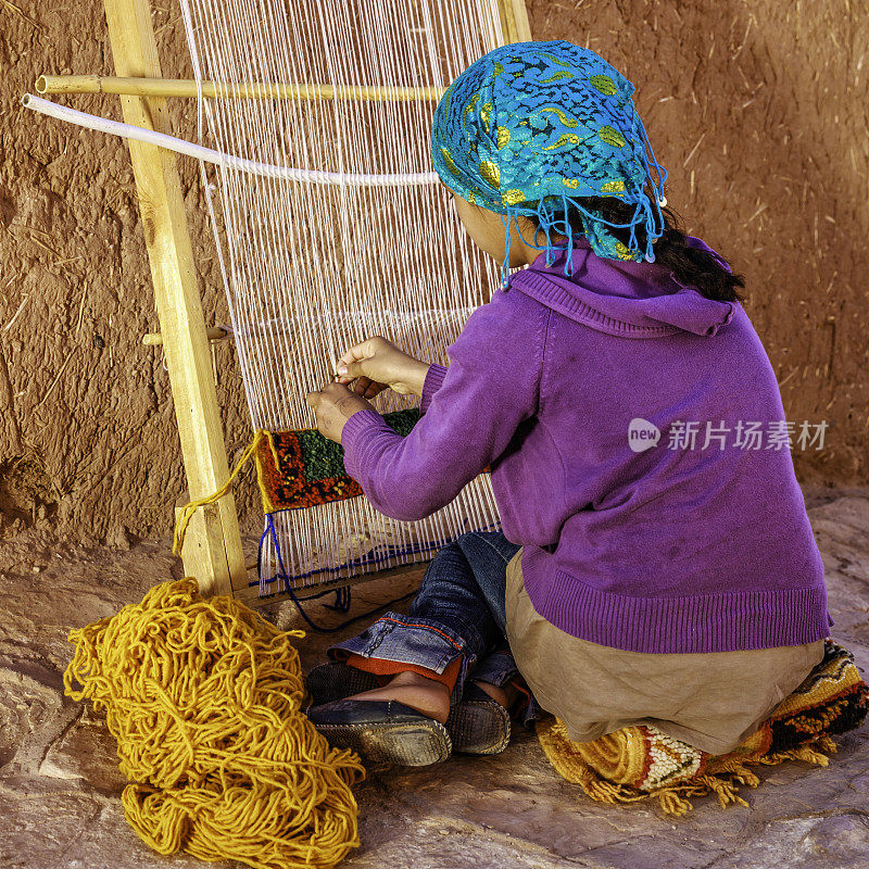 在摩洛哥瓦尔扎扎特编织纺织品的柏柏尔少女