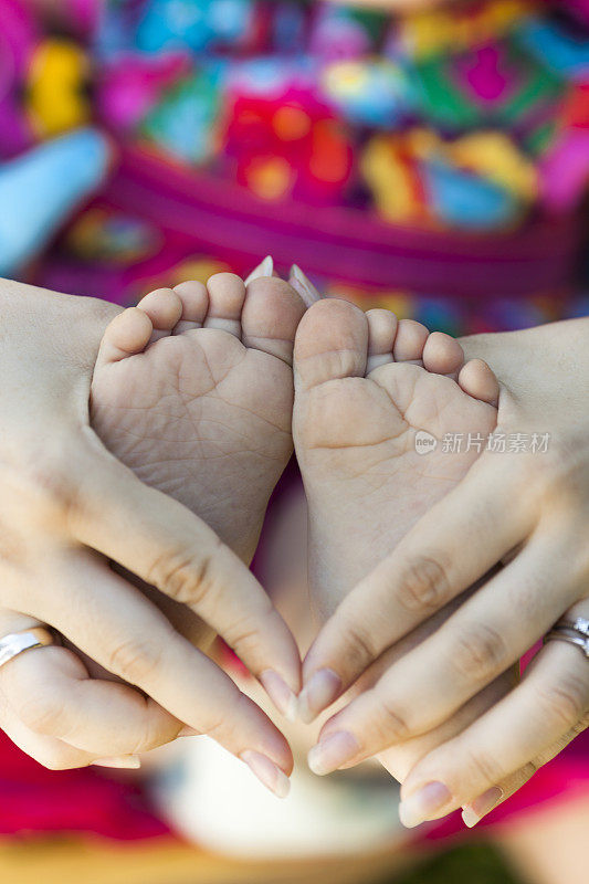 婴儿的脚和她母亲的手