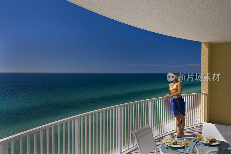 年轻女子站在阳台上俯瞰墨西哥湾