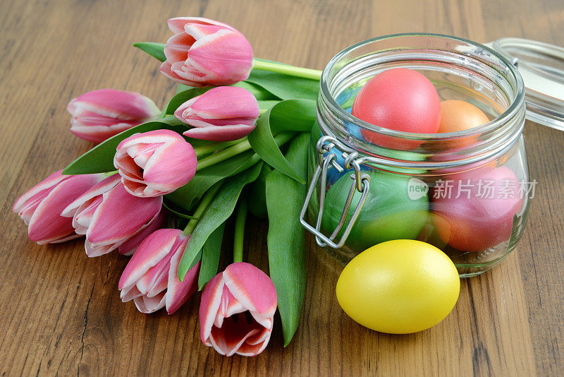 装有粉色郁金香和鸡蛋的玻璃罐子