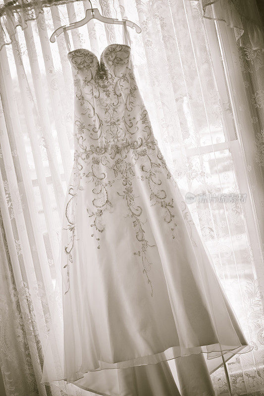 传统的婚纱挂在挂窗帘的窗户上