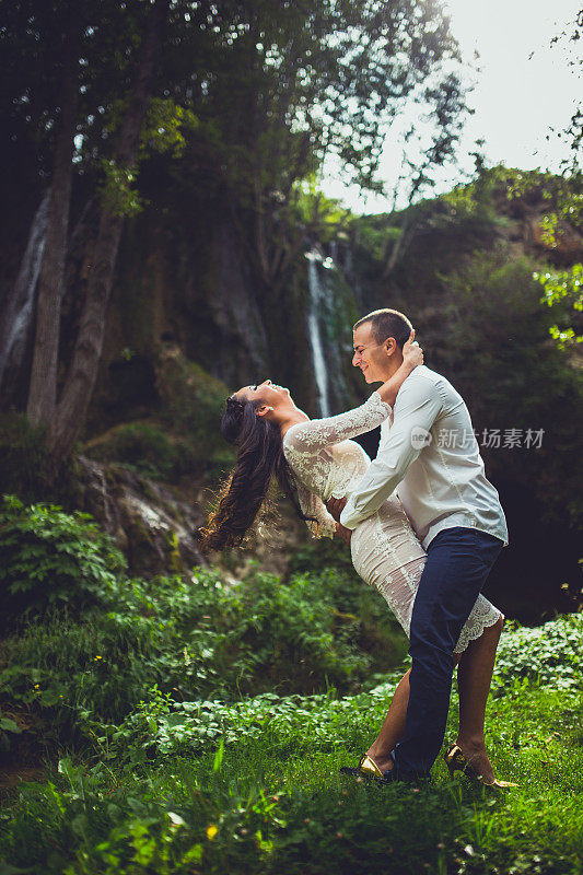 男人和女人在瀑布前互相抱着