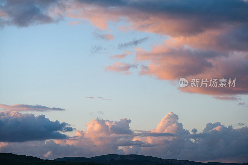 黄昏的天空是橙色、粉红色和蓝色的