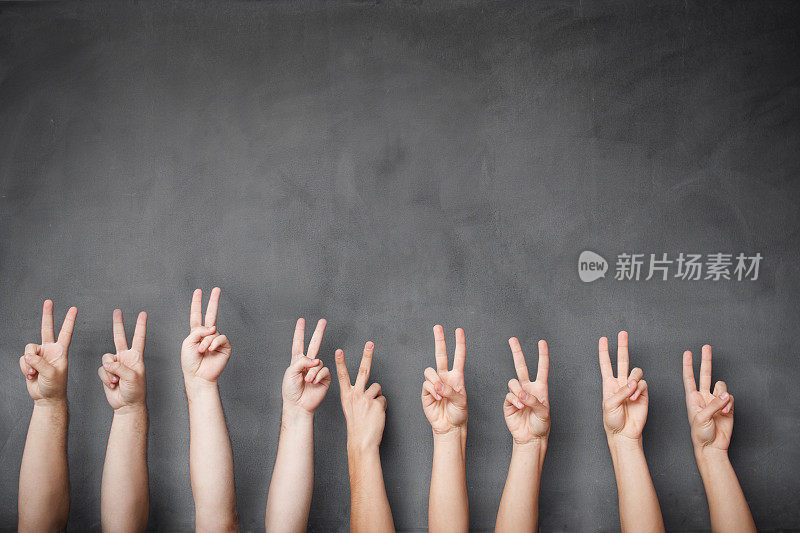 一组学生在黑板上举手表示胜利