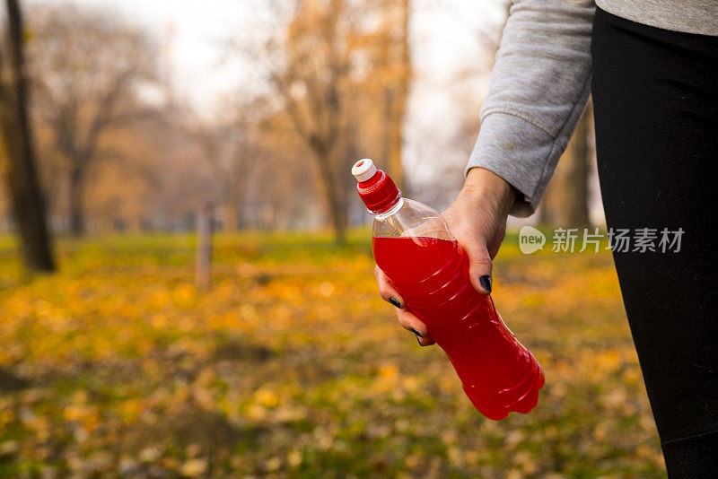 成熟的女人拿着权力饮料，近距离看