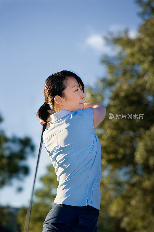 女高尔夫球手挥杆击球