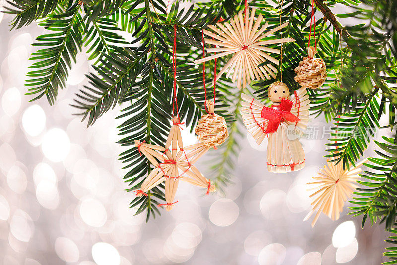 挂在松树上的圣诞装饰，背景有灯光