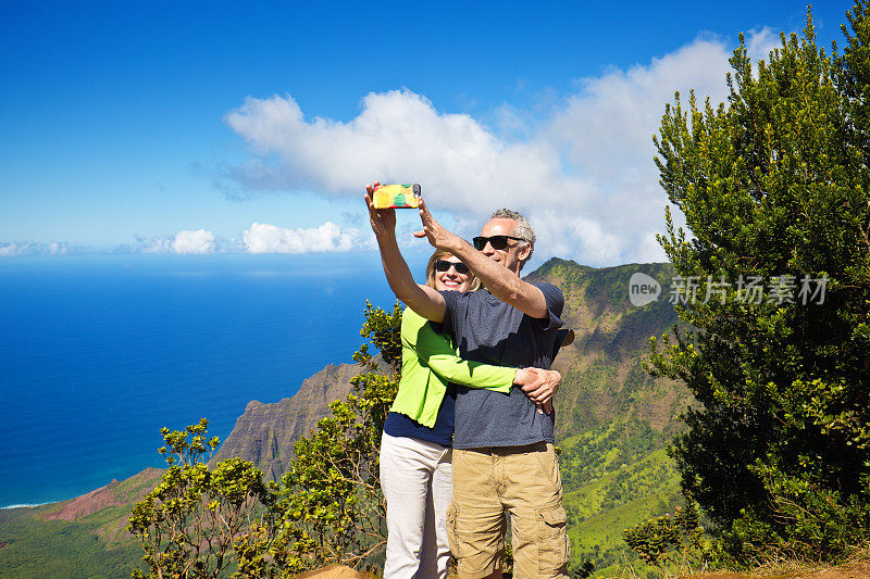 一对情侣在夏威夷考艾岛威美亚峡谷州立公园卡拉劳海滩自拍