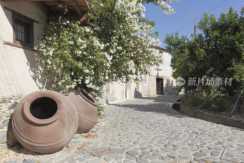 塞浦路斯村庄的鹅卵石街道，上面放着棕色的希腊陶罐