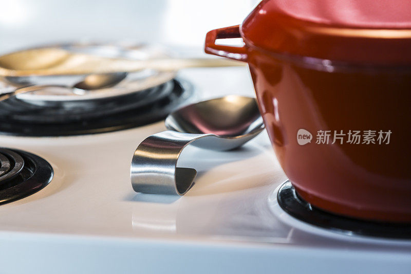 厨房电炉上的红色搪瓷烹饪锅特写