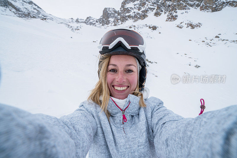 年轻女子在滑雪坡上自拍