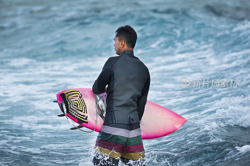 年轻的男性冲浪者在夏威夷考艾岛的水