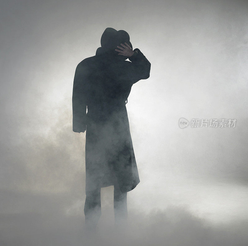 穿着风衣站在雾里的女人