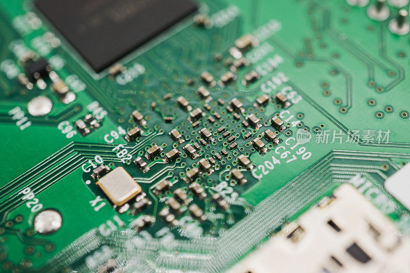 用于电子工程的带有小电容、电阻和微芯片的绿色电路板。