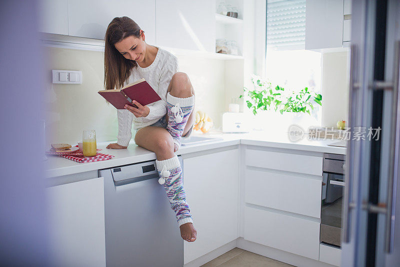 在厨房看书的漂亮女人