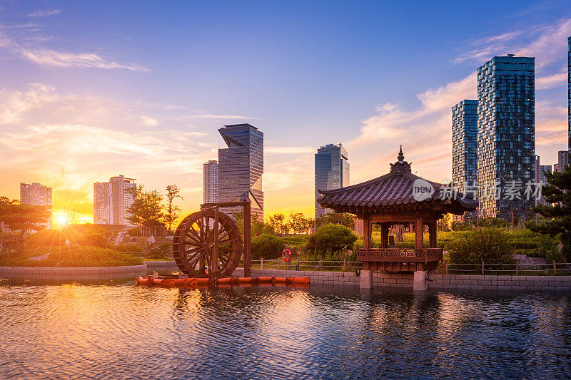 韩国仁川松岛国际商务区中央公园的美丽日落，传统和现代建筑。