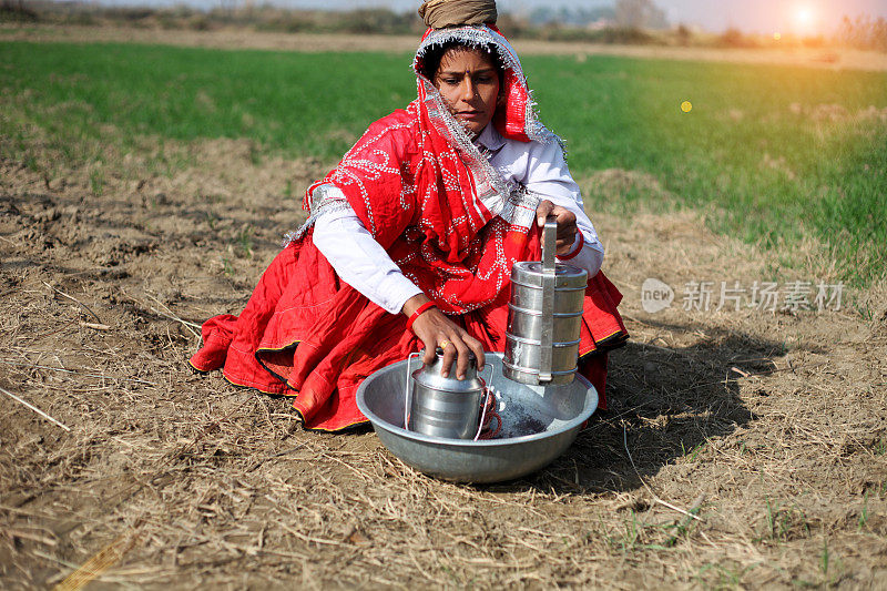 印度妇女坐在地里准备午餐