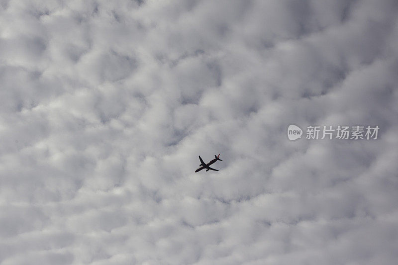 一架商业客机在土耳其伊斯坦布尔云层下飞越博斯普鲁斯海峡