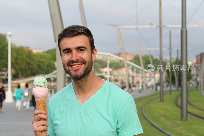 心满意足的年轻男子拿着美味的冰淇淋
