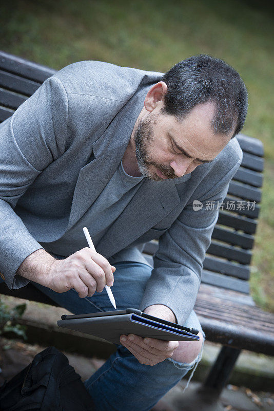 一个成年人在公园里研究数字平板电脑