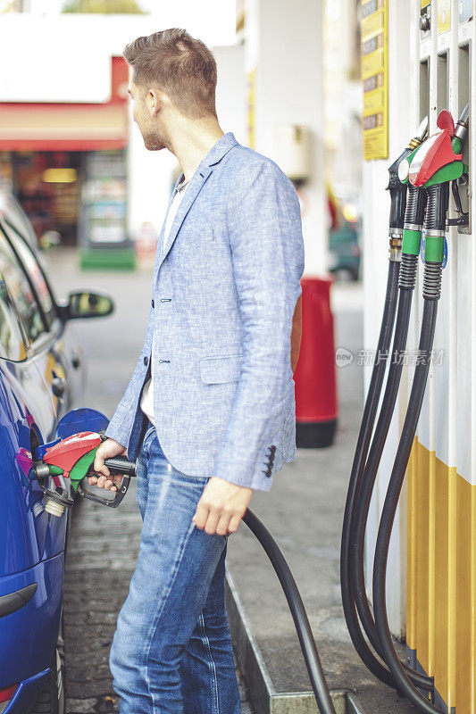 一个年轻人正在给他的汽车加油
