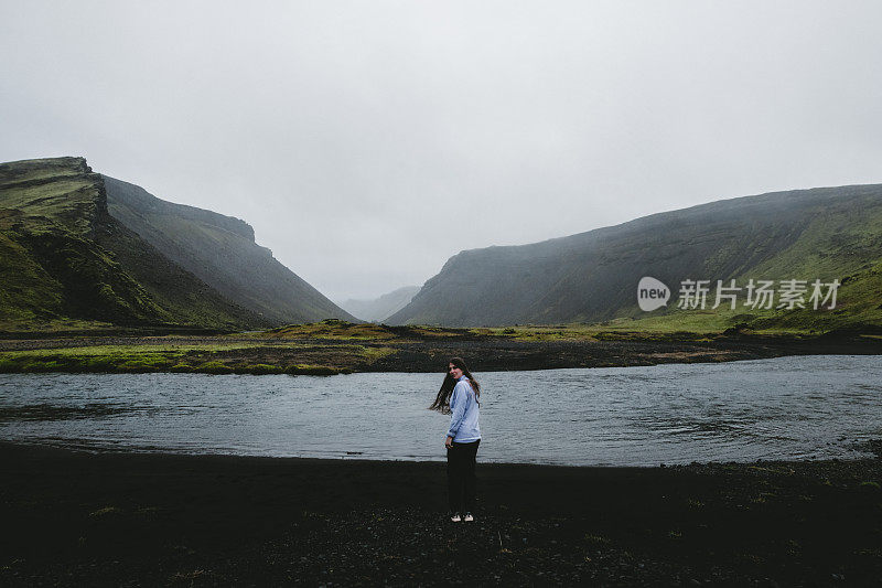 女人呆在冰岛高地美丽的湖和山附近