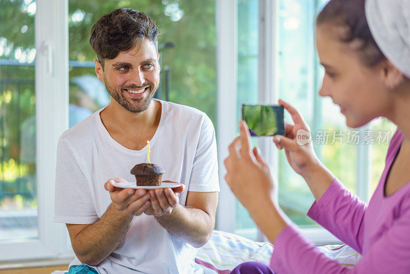 年轻夫妇在床上庆祝生日