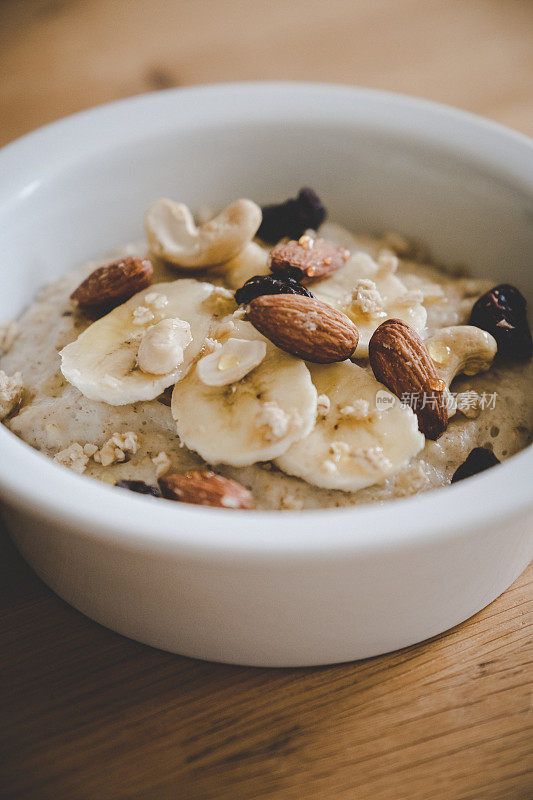 早餐燕麦粥配香蕉片，杏仁，腰果，葡萄干和蜂蜜