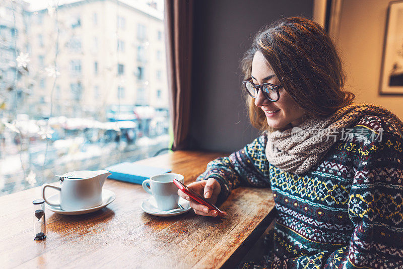 一个女人在café上用手机发短信