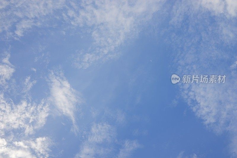 云彩和阳光在明亮的蓝色天空背景