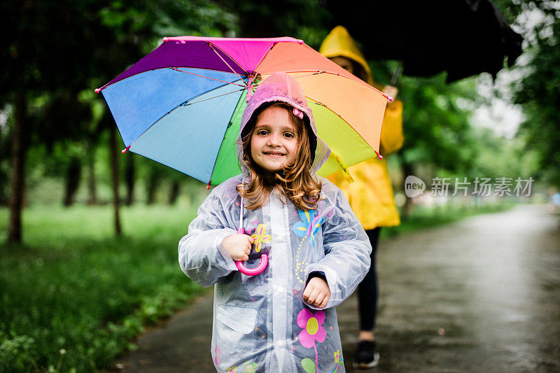 小女孩撑着伞走路的肖像