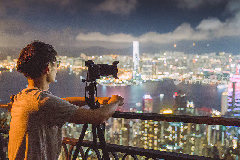 年轻的亚洲游客冒险拍摄香港的城市天际线在香港的famaus旅游胜地维多利亚峰