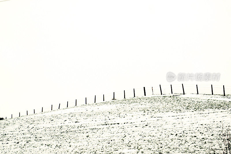 雪地里乡间小路上的篱笆