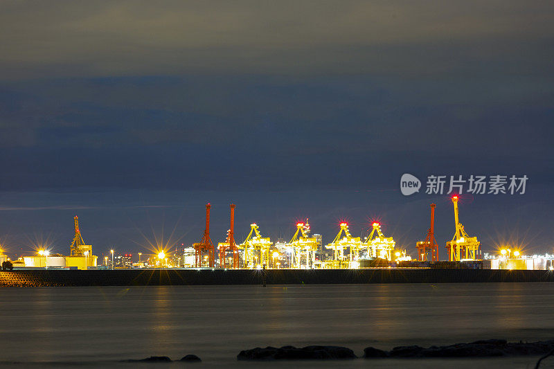 海湾在夜晚与油轮在炼油厂港口和城市天际线，背景与复制空间