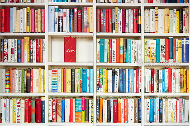 图书馆里，白色的书架上，五颜六色的书，一部分用红色的礼品包装，用爱心包装
