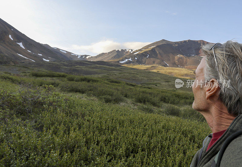 成熟的男人沿着山脊徒步旅行