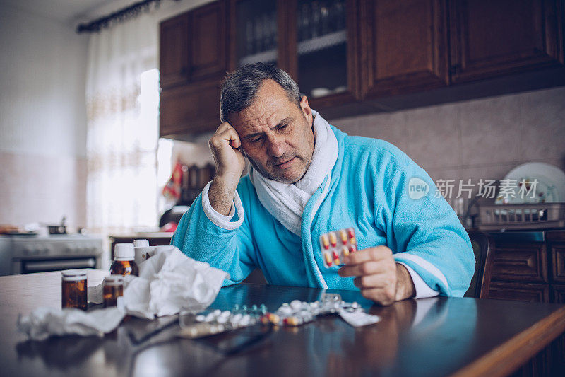 生病的老人坐在桌子旁