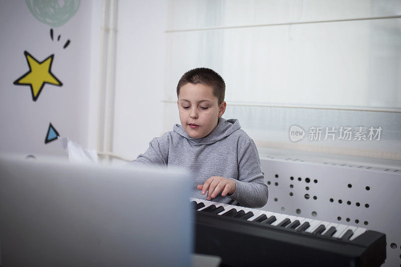 一个男孩在跟他的教授上在线钢琴课
