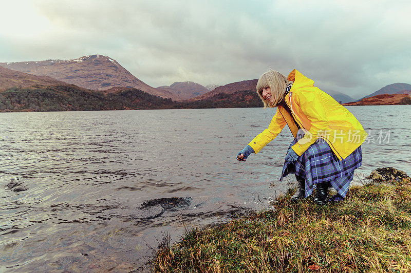 在苏格兰高地的阿尔凯格湖，一名女子在刨平的石头