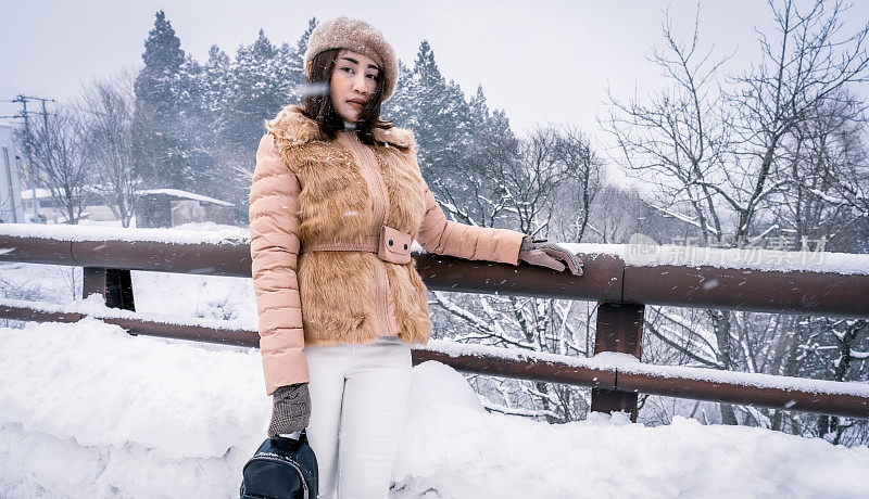 年轻的女游客在日本玩雪玩得很开心