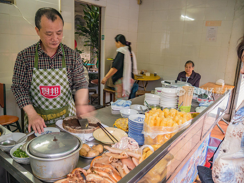 不熟悉的中国老板厨师在中国汕头市闹市区小巷的早餐餐厅烹饪。汕头市潮汕人在中国广东省