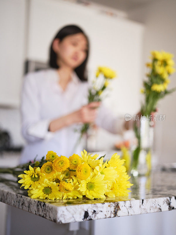 亚洲妇女在她的家里插花