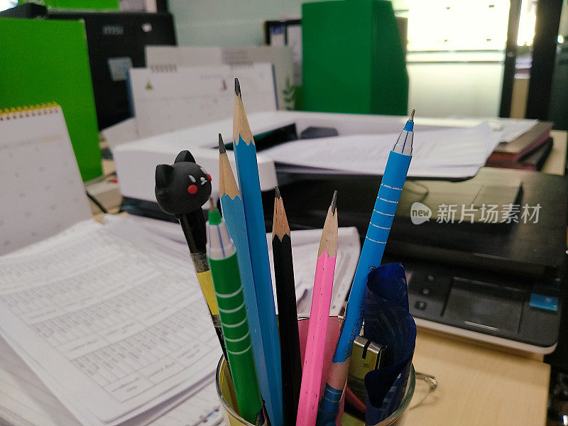 彩色铅笔和钢笔指向书桌上的办公室。