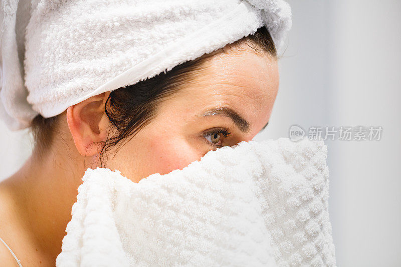 妇女洗澡后戴毛巾在头上用毛巾擦脸