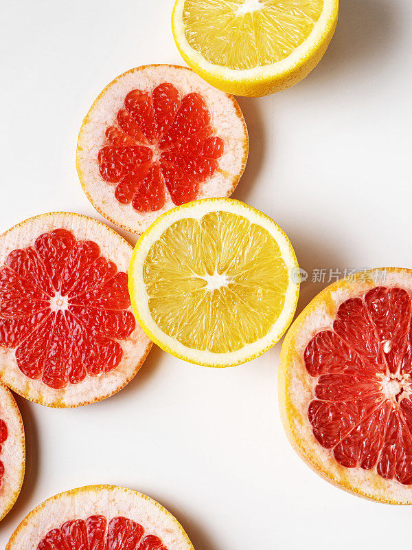 一半的柑橘类水果在白色的背景下，橙子和葡萄柚分离在白色的背景下，橙子切片，