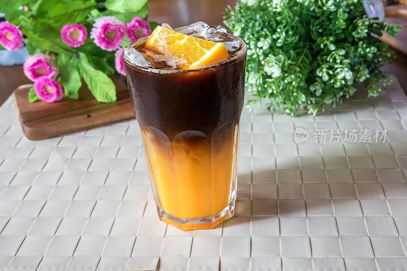 两层混合橙汁和黑咖啡。橙色和咖啡鸡尾酒在木制背景上。混合了橙汁的冰咖啡。黑咖啡奎宁