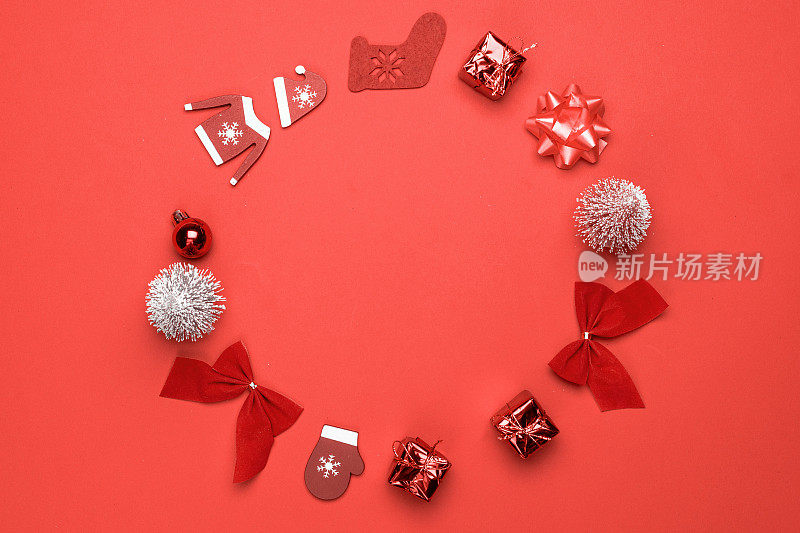 圣诞节销售。袜子，礼物，冬天的树，丝带和蝴蝶结的形状框架在红色的背景贺卡。冬季节日构图用拷贝空间。