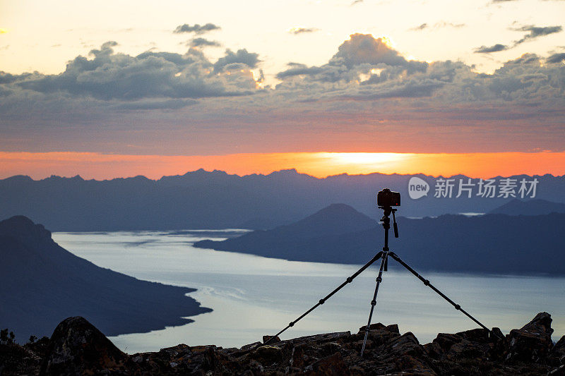 日落时分，三脚架和摄像设备安装在山上