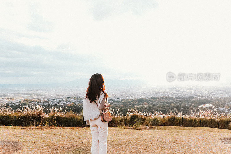 亚洲年轻女子仰望天空，满怀希望，回顾往事。